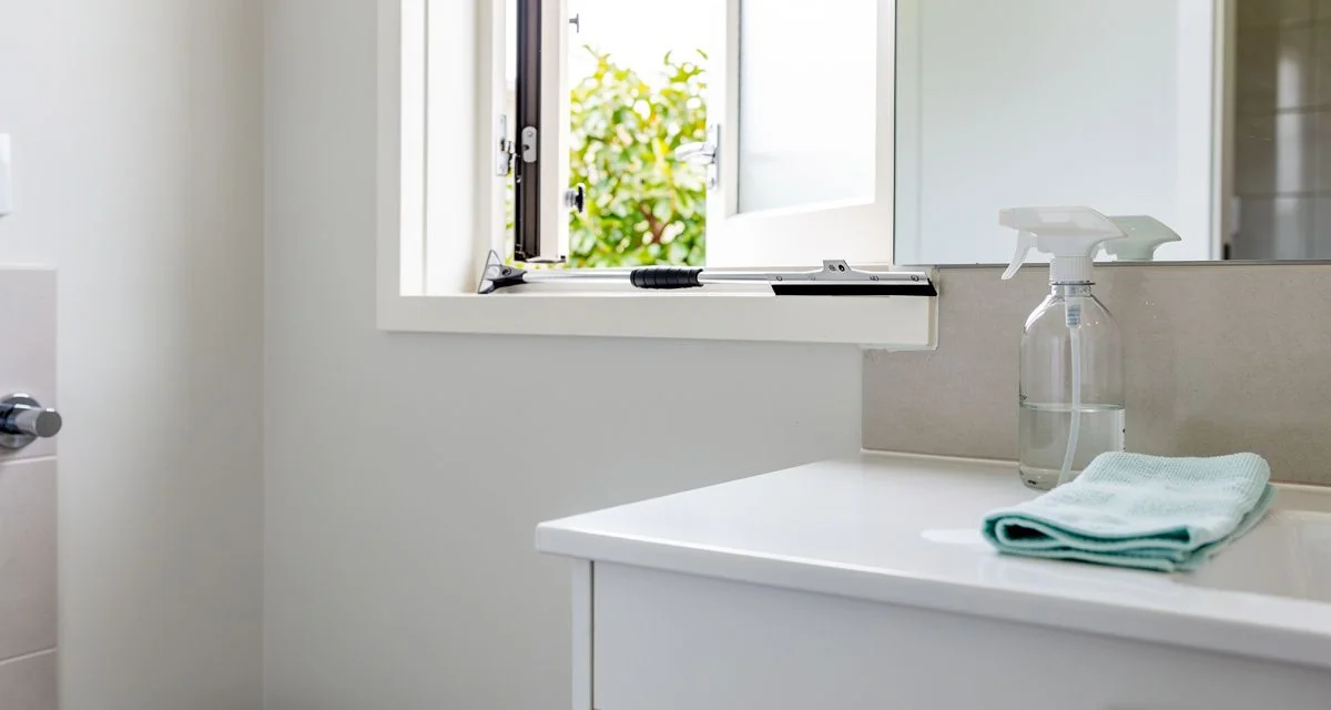 Cleaning cloth and spray bottle on the vanity of a Lower Hutt bathroom with an open window