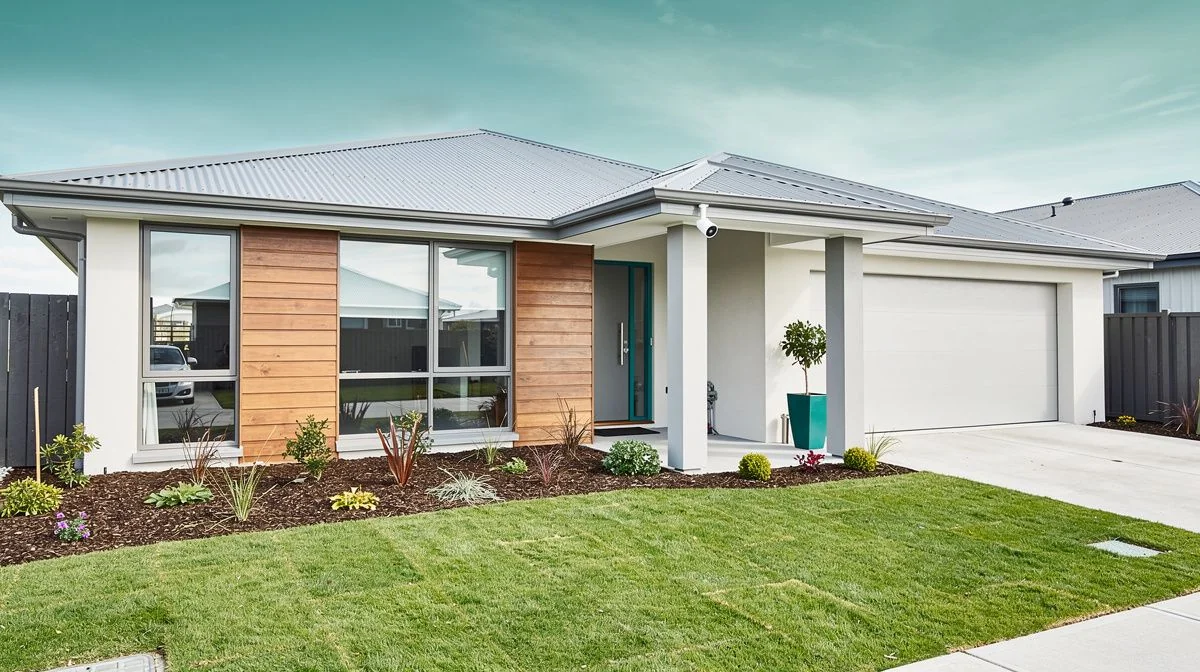 A modern Christchurch home with a security camera mounted under the eave and a freshly landscaped section with no established trees