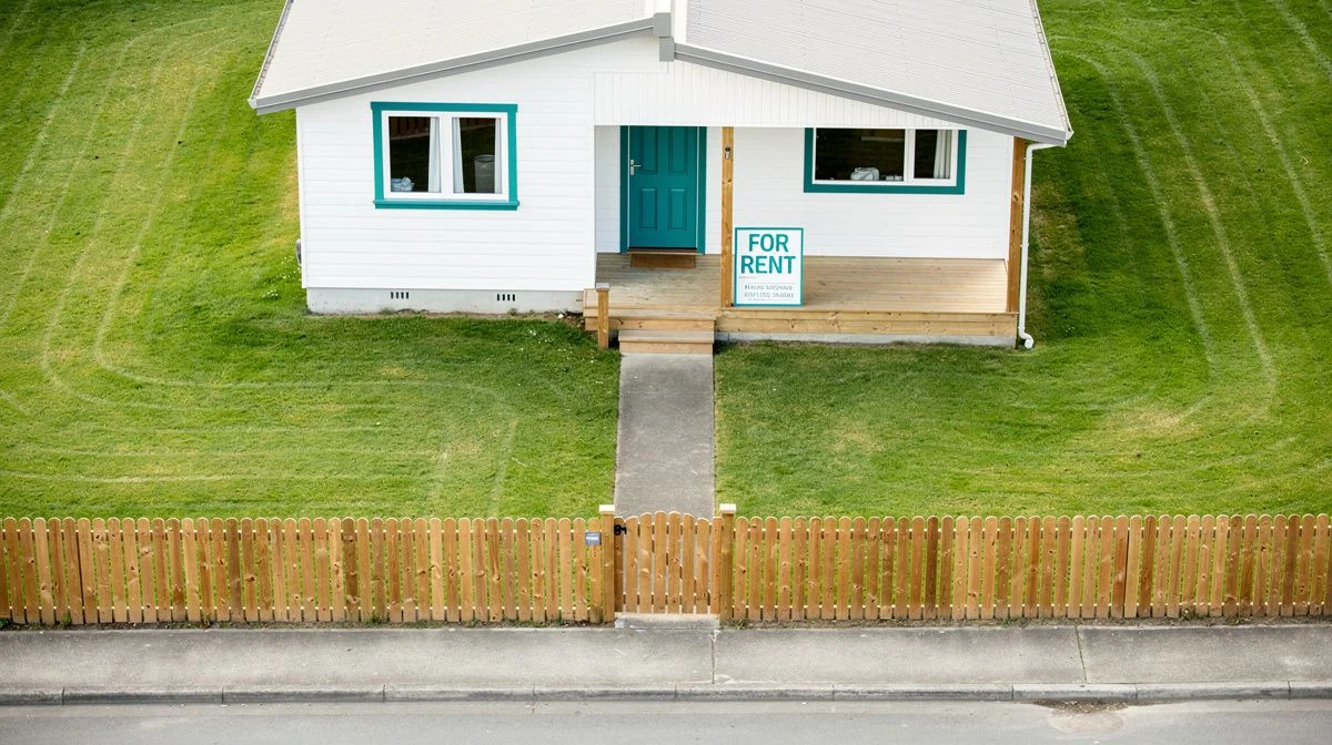 Weatherboard rental house with a for-rent sign on the porch