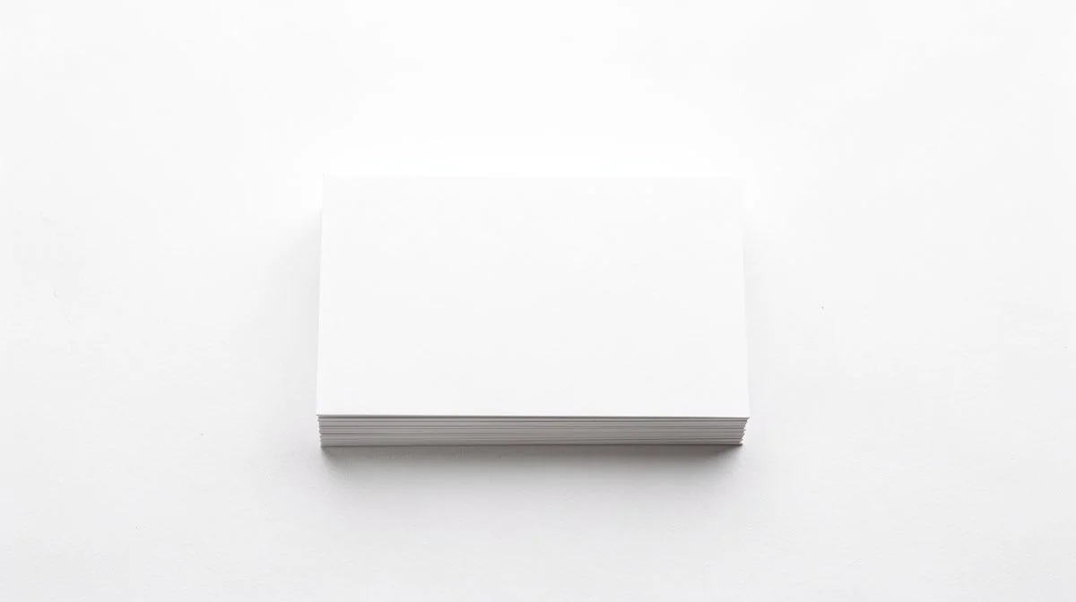 A neat stack of blank plain white cards on a bright white surface